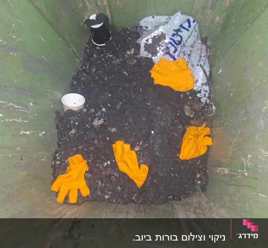 כפפות כתומות בתוך מיכל ירוק עם אדמה ופסולת